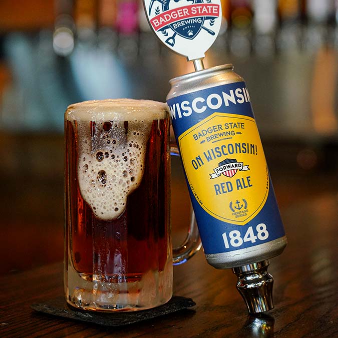 A glass of red ale beside a Wisconsin-themed beer tap at Pizza Beloit’s Downtown Den bar.