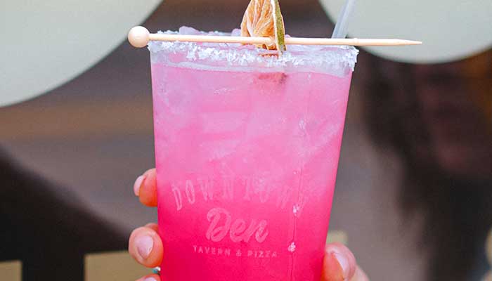 Bright pink drink with salt rim, perfect to sip at Pizza Beloit’s Downtown Den slice bar.